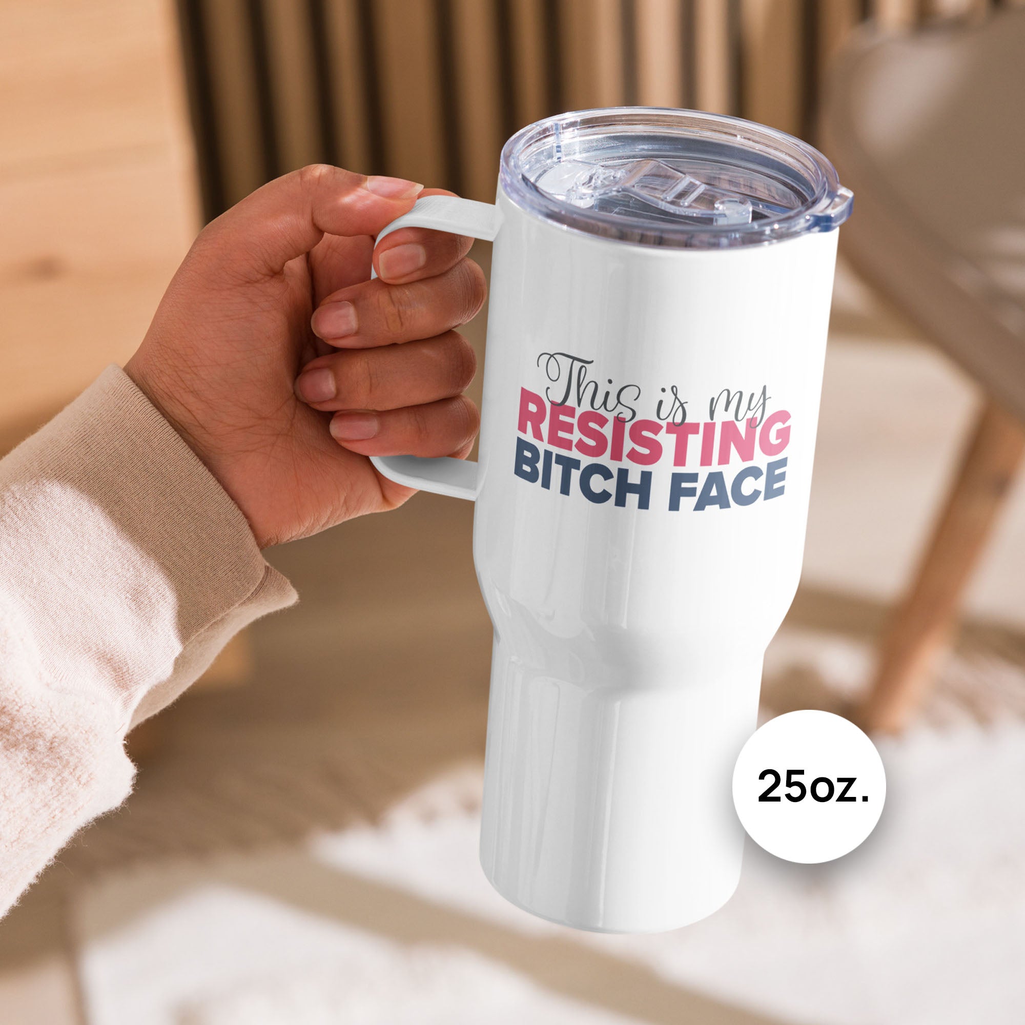 Person on an outdoor deck holding 25 ounce white insulated travel tumbler with the phrase “This Is My Resisting Bitch Face” printed in script and bold text.