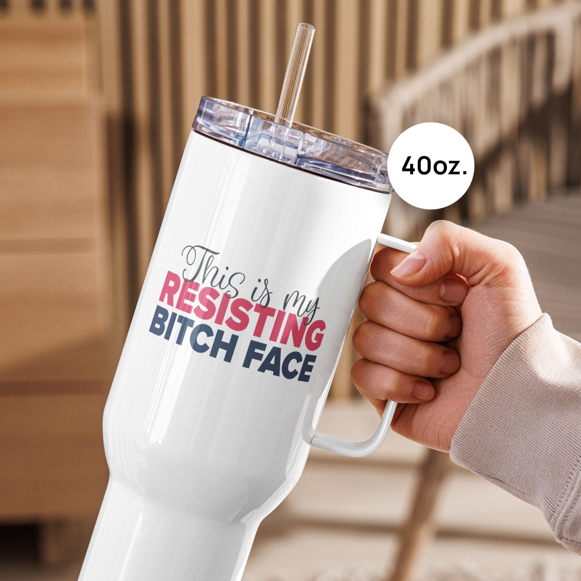 Person on an outdoor deck holding 40 ounce white insulated travel tumbler with the phrase “This Is My Resisting Bitch Face” printed in script and bold text.