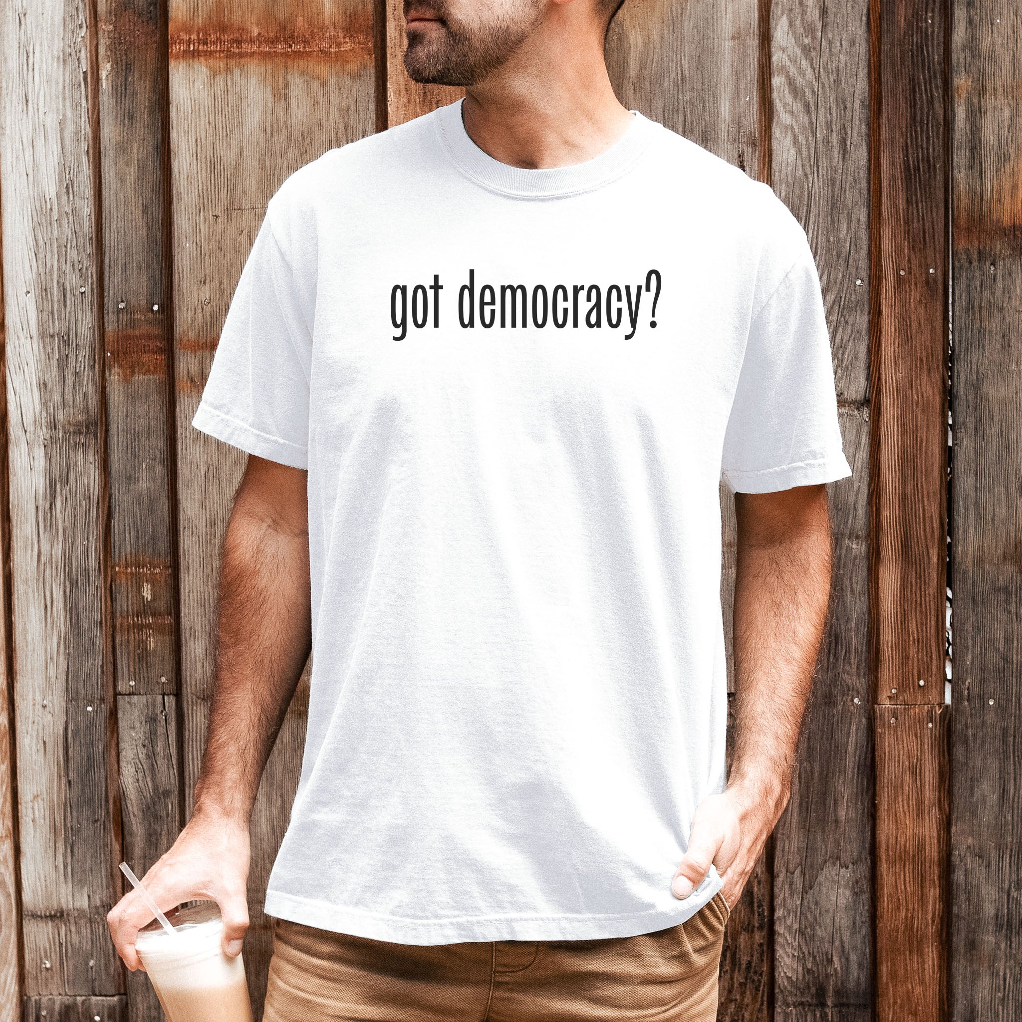 Male model wearing white t-shirt with black text reading “got democracy?” in minimalist font, styled like the classic “got milk?” campaign design.