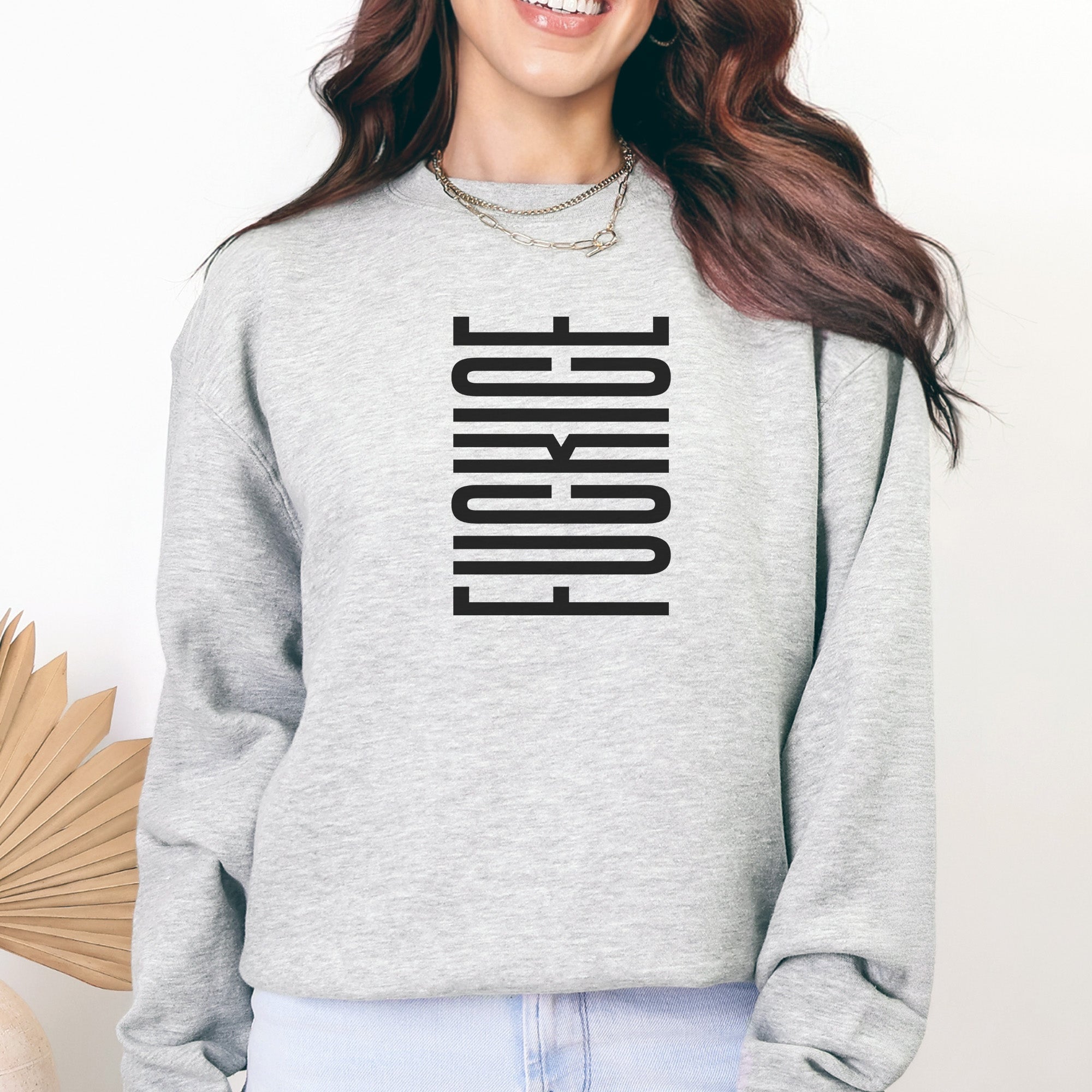 Female model wearing heather grey sweatshirt with geometric hidden text message that reads "fuck ice."