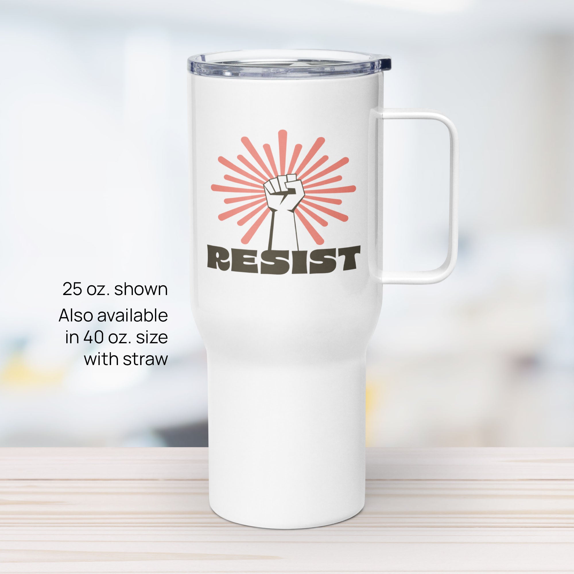 25 ounce white stainless steel tumbler with handle, with graphic text "resist" below a raised fist and coral color burst.