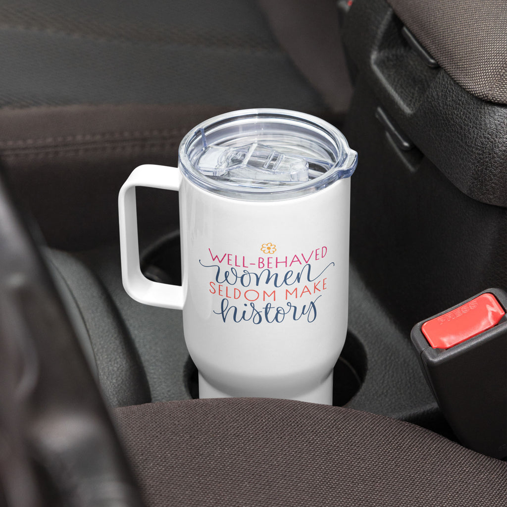 25 ounce white insulated travel tumbler with handle featuring the quote “Well-Behaved Women Seldom Make History” in colorful stylized text block, in a car cup holder.