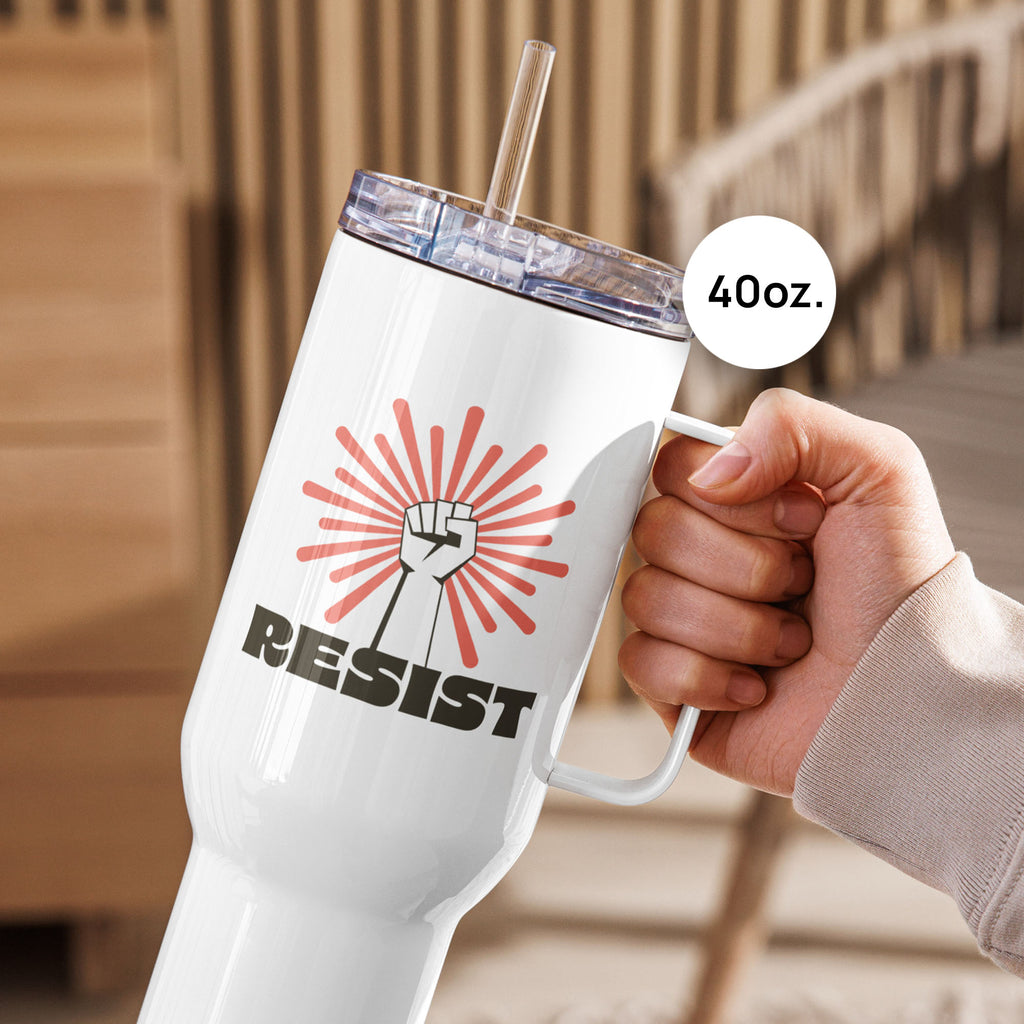 40 ounce white stainless steel tumbler with handle, with graphic text "resist" below a raised fist and coral color burst, held by a person on an outdoor deck.