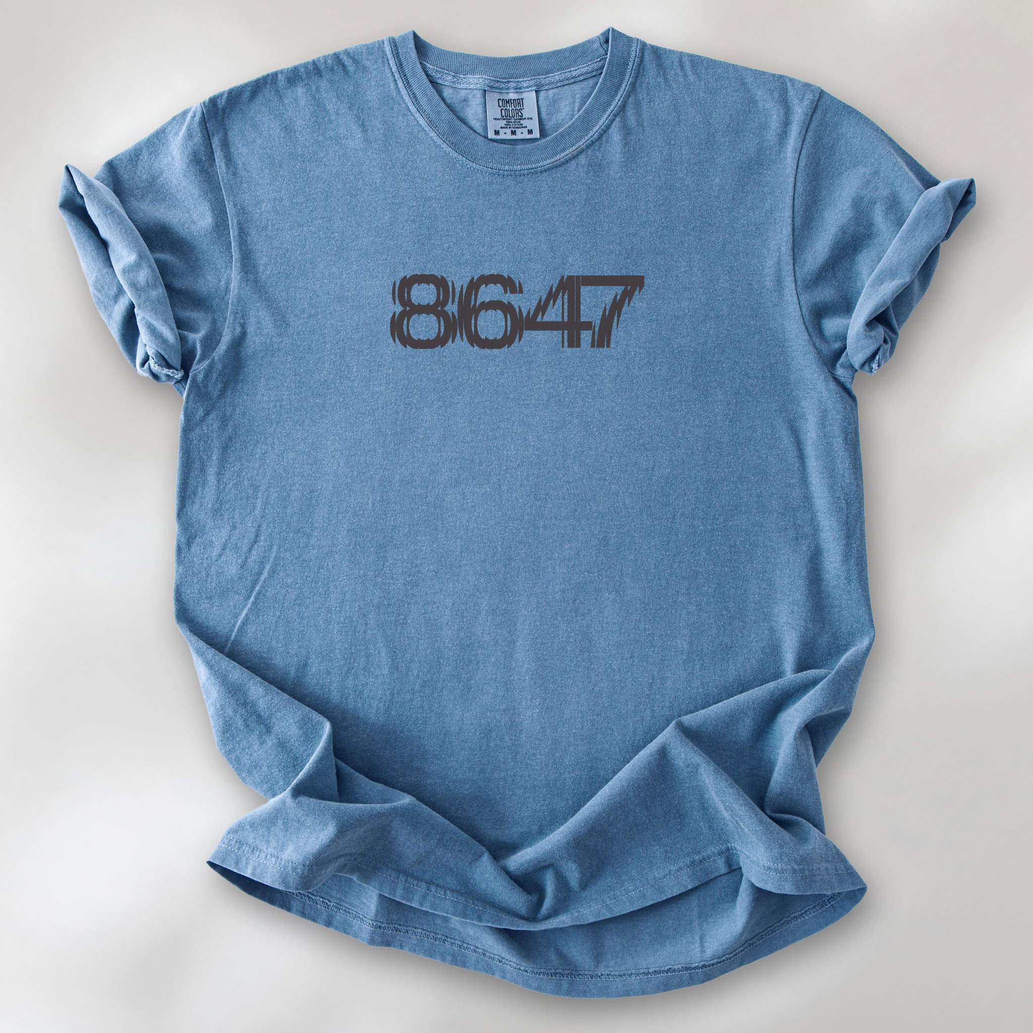 Blue jean unisex t-shirt featuring the number “8647” in bold, clean typography with glass block effect, referencing Trump impeachment.