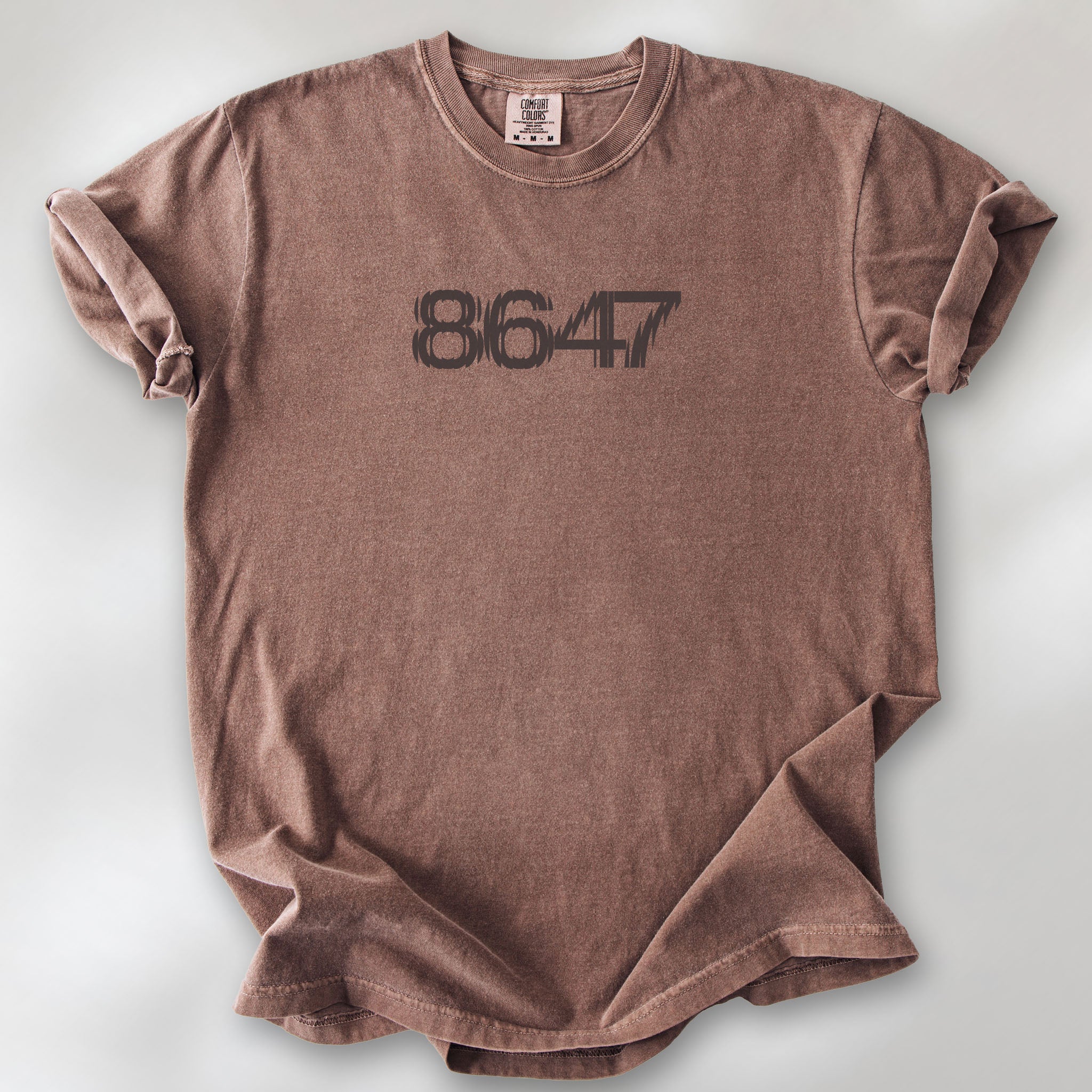 Espresso unisex t-shirt featuring the number “8647” in bold, clean typography with glass block effect, referencing Trump impeachment.