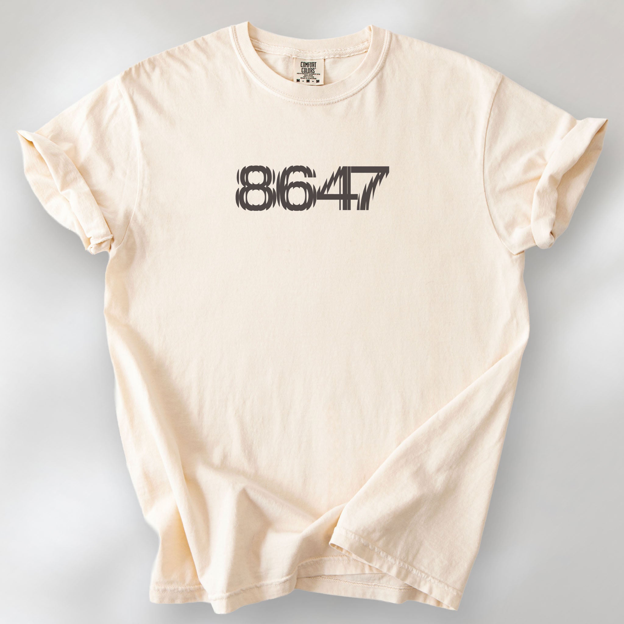 Ivory t-shirt featuring the number “8647” in bold, clean typography with glass block effect.