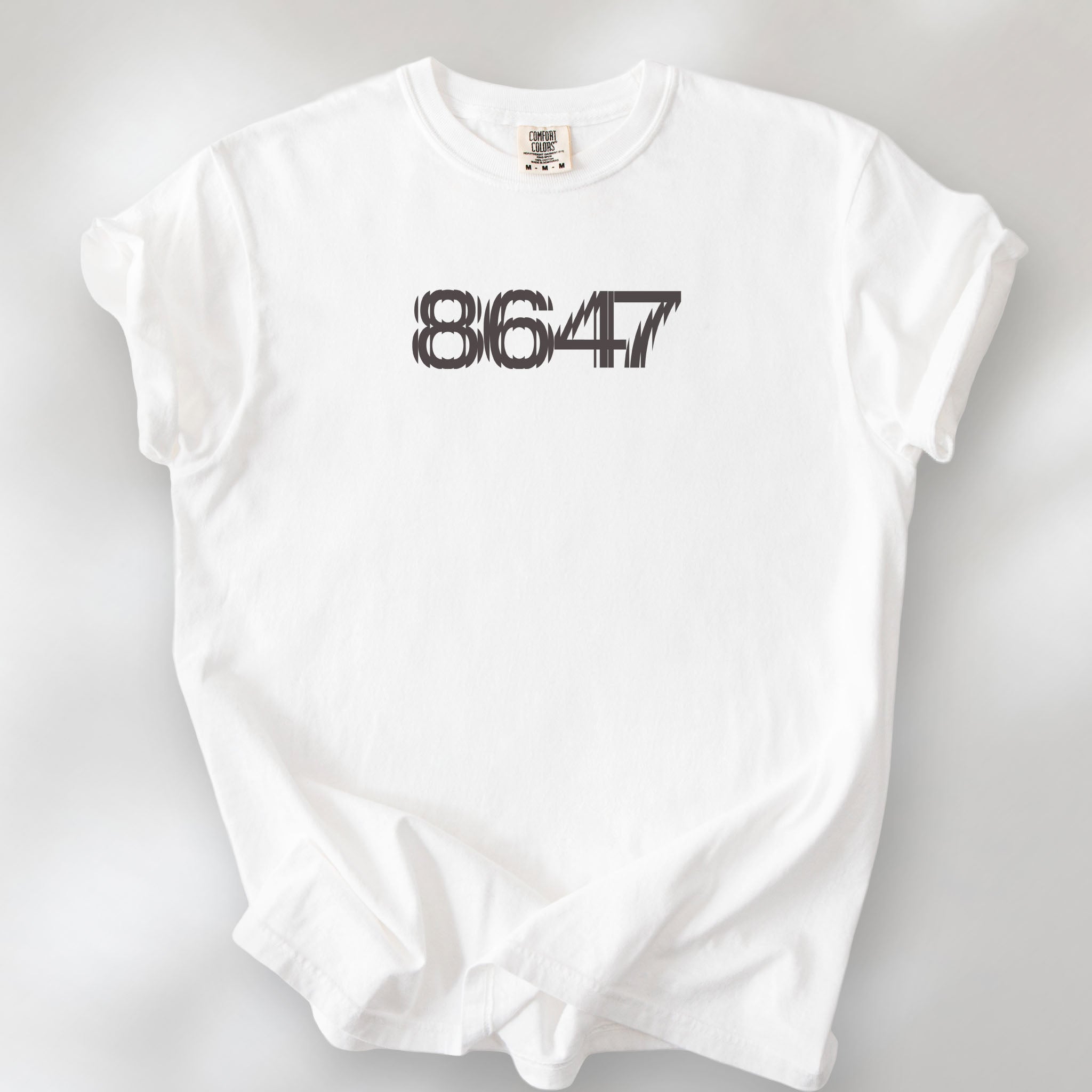 White t-shirt featuring the number “8647” in bold, clean typography with glass block effect.