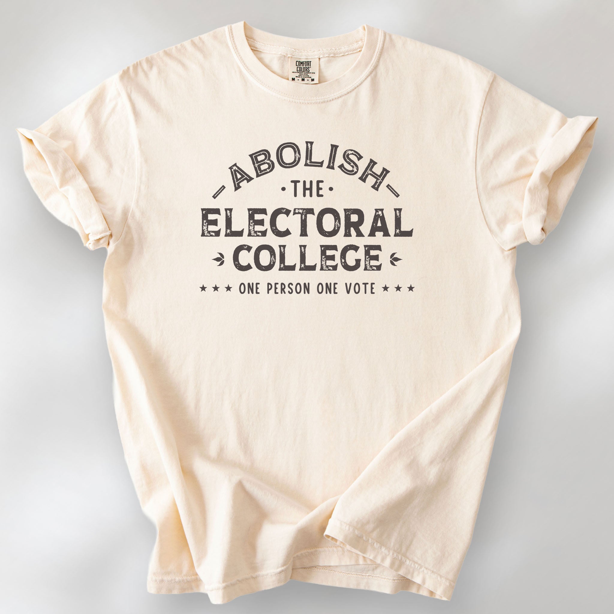 Ivory t-shirt with distressed text reading “Abolish the Electoral College One Person One Vote” in vintage style design