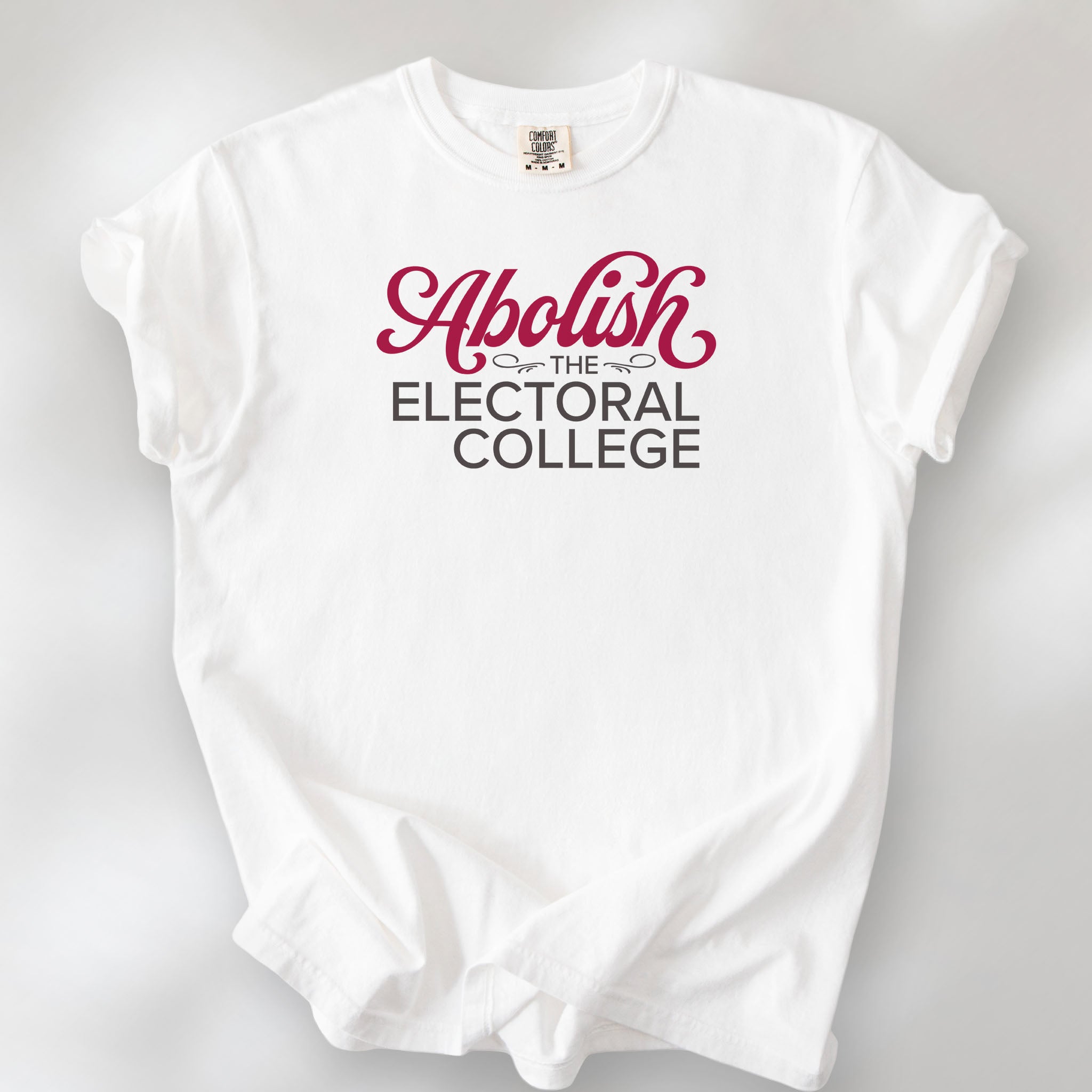 White t-shirt with stylized text reading “Abolish the Electoral College” in muted red and gray.