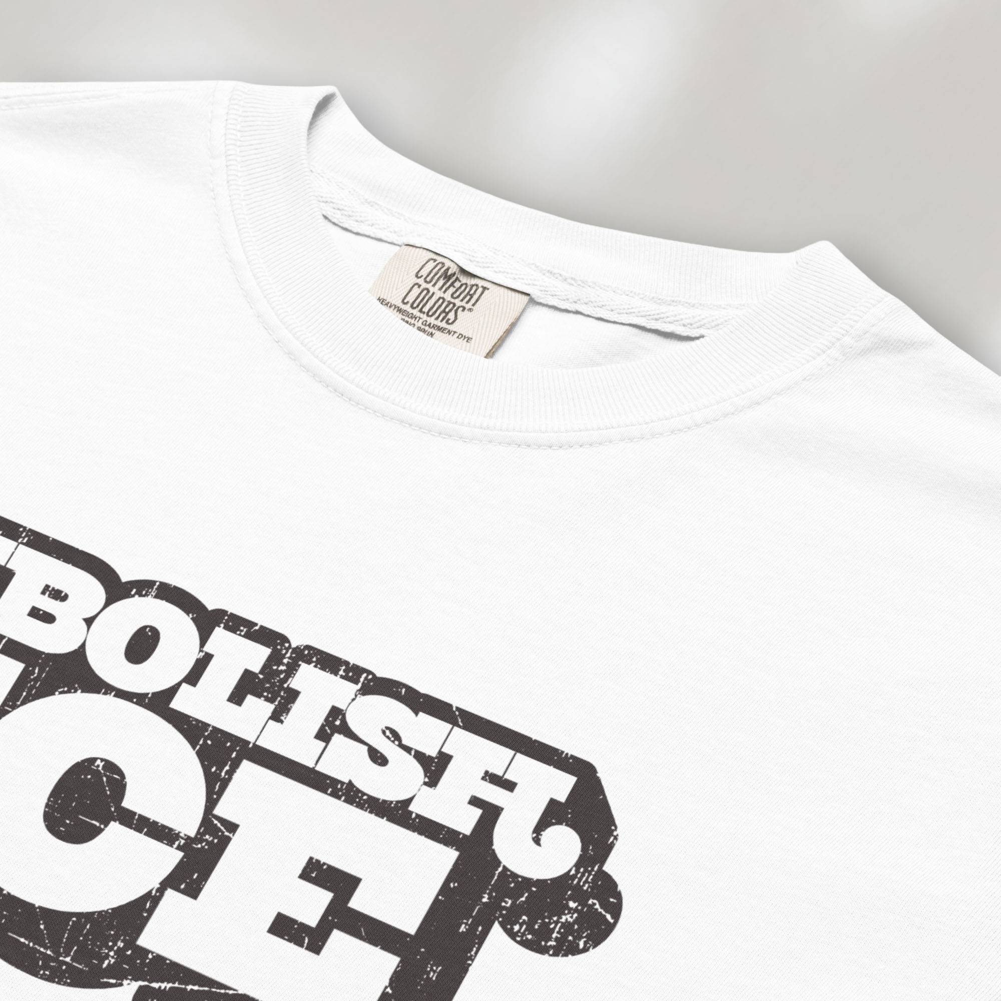 Closeup detail of white t-shirt with retro distressed text reading “Abolish ICE” for immigration justice and anti-ICE activism.