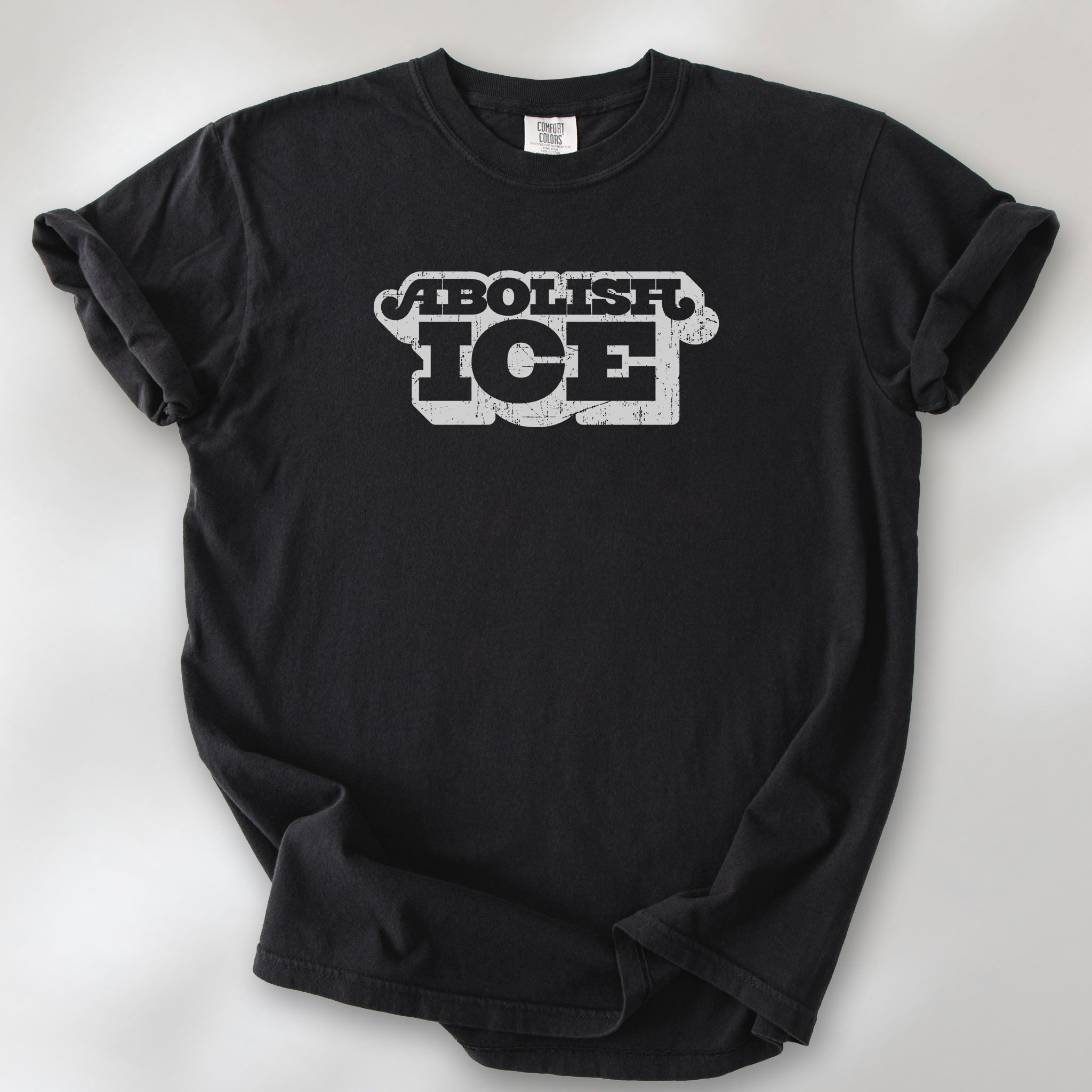 Black t-shirt with retro distressed text reading “Abolish ICE” for immigration justice and anti-ICE activism.