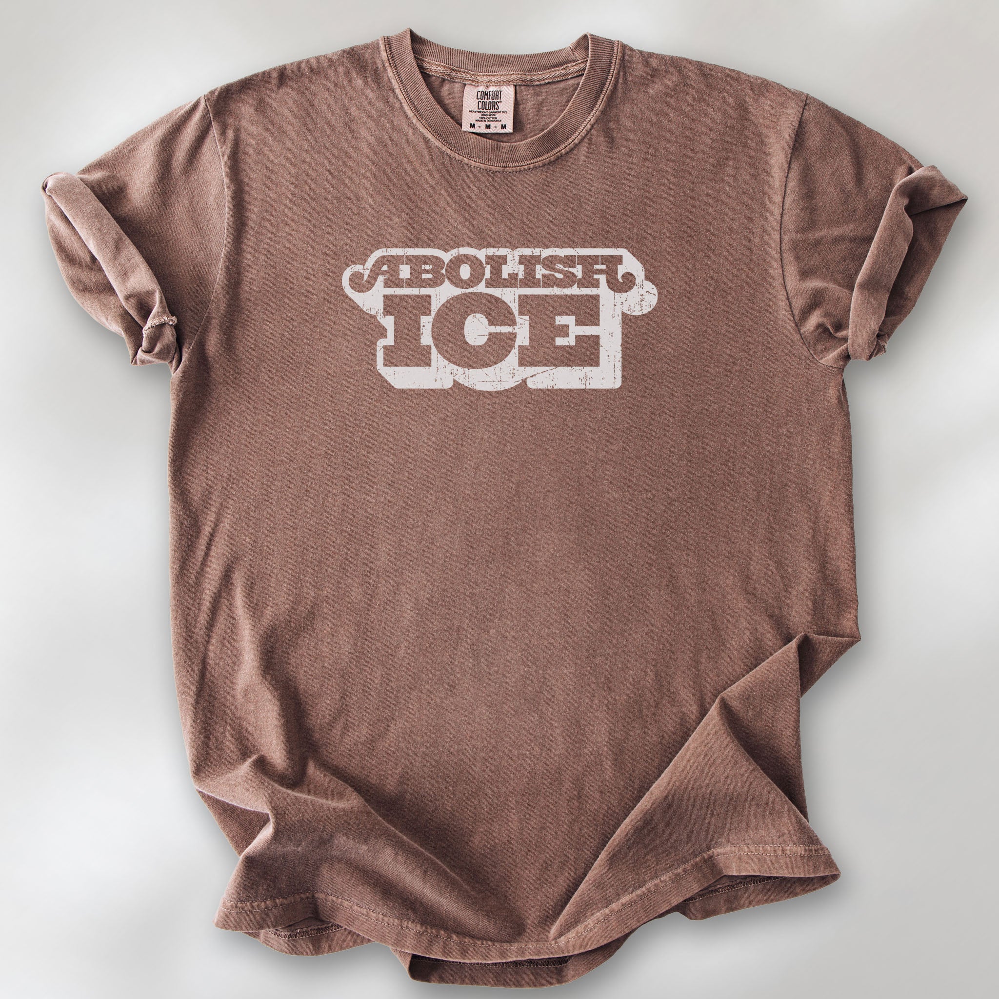 Espresso t-shirt with retro distressed text reading “Abolish ICE” for immigration justice and anti-ICE activism.
