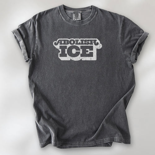 Pepper t-shirt with retro distressed text reading “Abolish ICE” for immigration justice and anti-ICE activism.