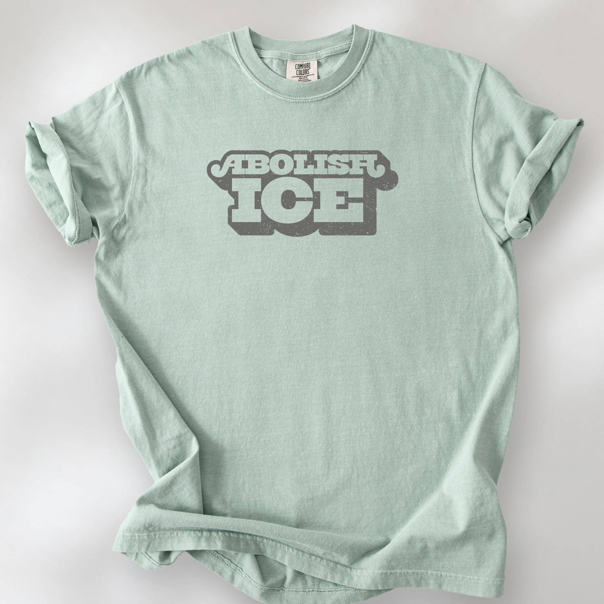 Bay t-shirt with retro text reading “Abolish ICE” for immigration justice and anti-ICE activism.