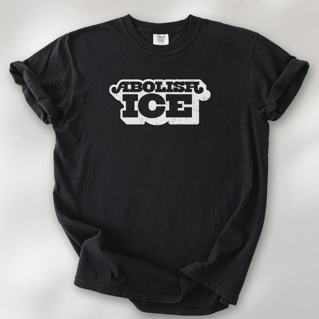 Black t-shirt with retro text reading “Abolish ICE” for immigration justice and anti-ICE activism.