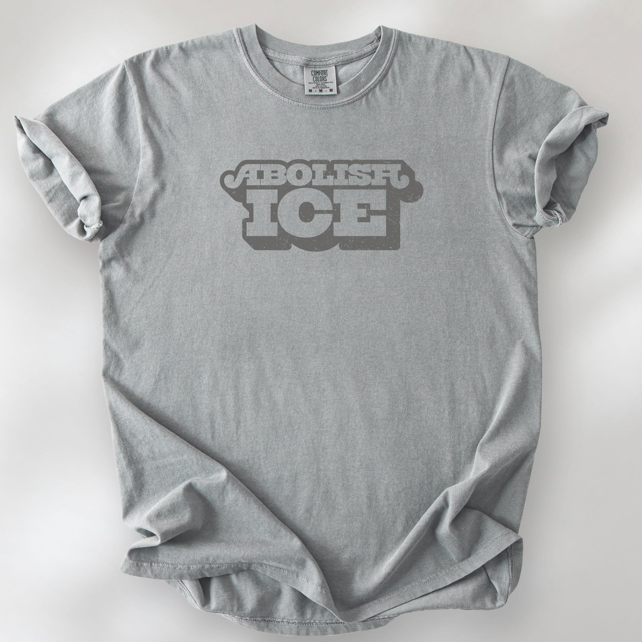 Granite t-shirt with retro text reading “Abolish ICE” for immigration justice and anti-ICE activism.