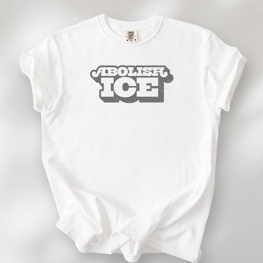 White t-shirt with retro text reading “Abolish ICE” for immigration justice and anti-ICE activism.