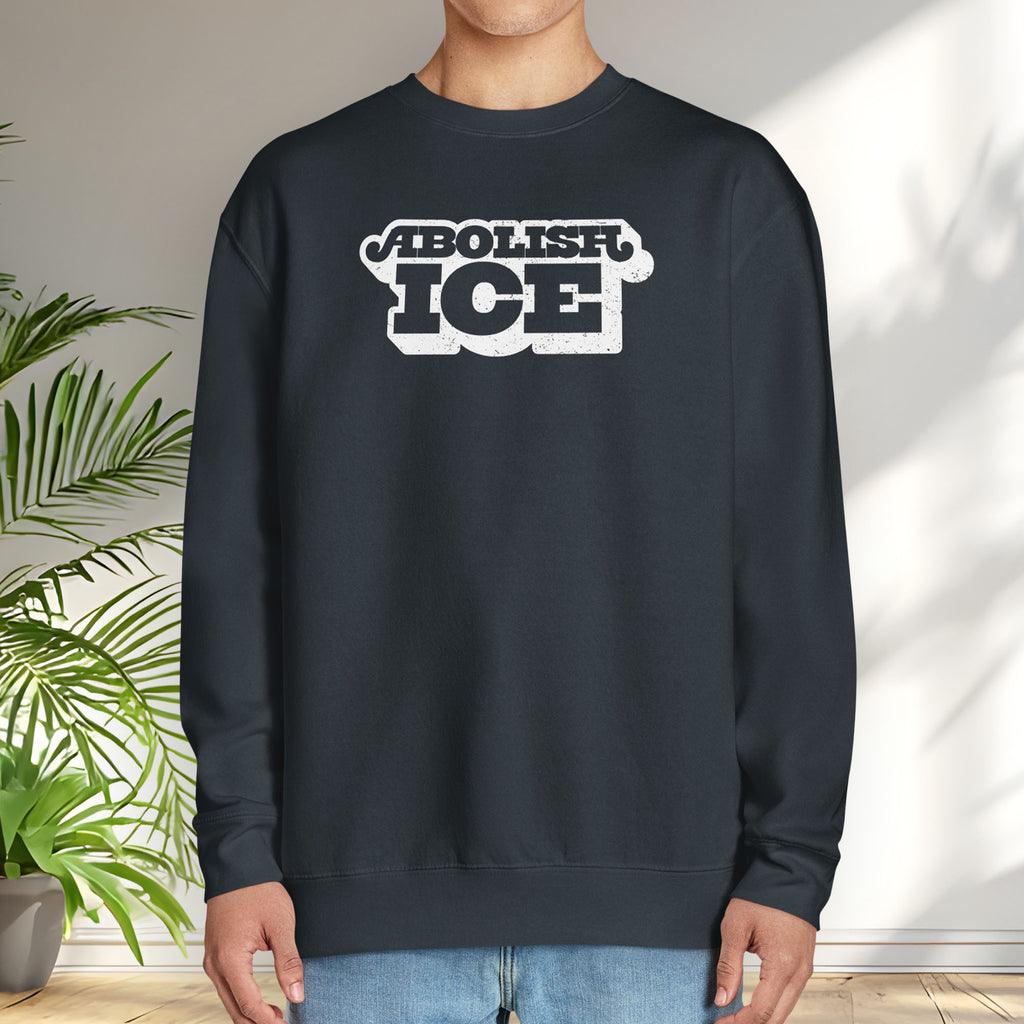 Male model wearing navy sweatshirt with retro text reading “Abolish ICE” for immigration justice and anti-ICE activism.