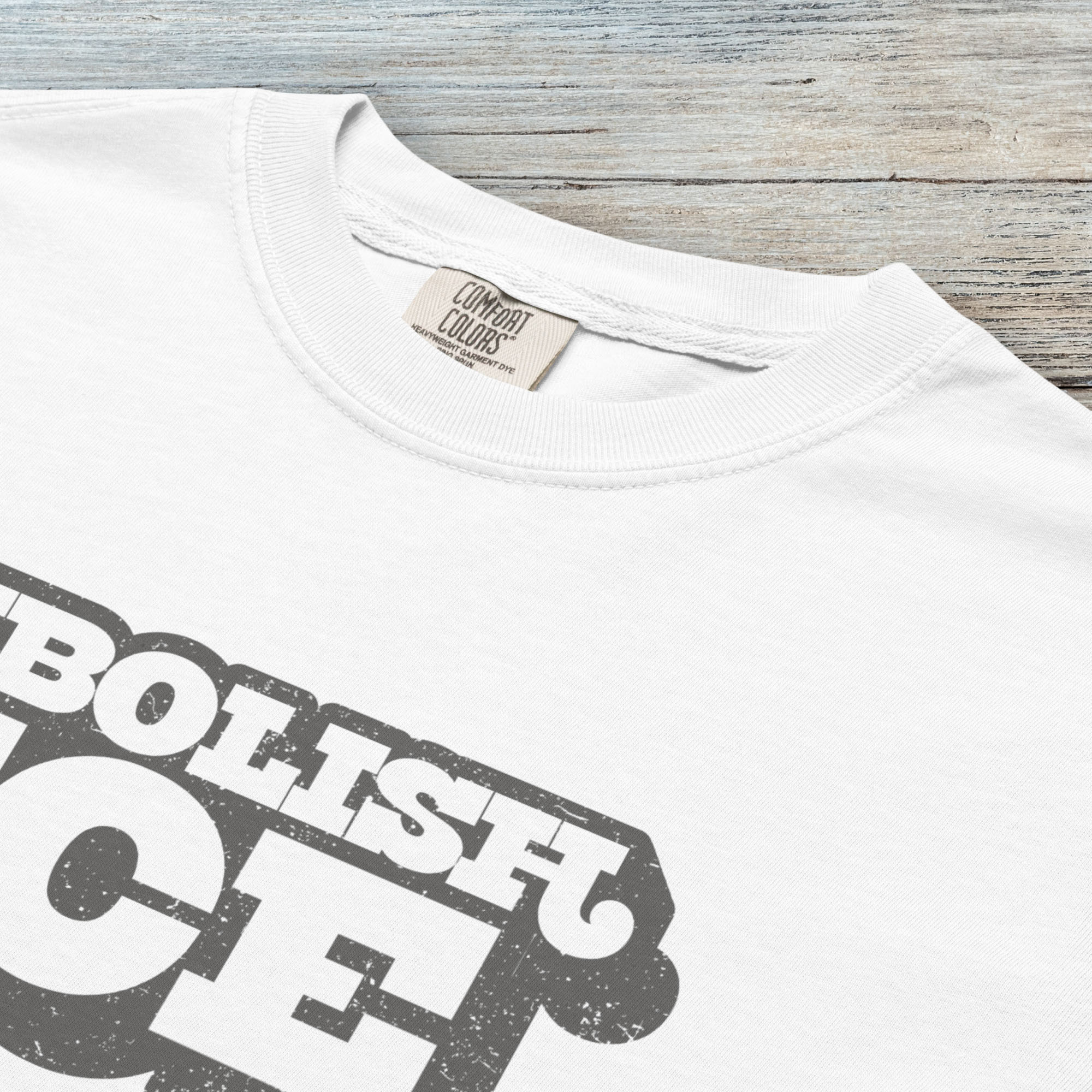 Closeup detail of white t-shirt with retro text reading “Abolish ICE” for immigration justice and anti-ICE activism.