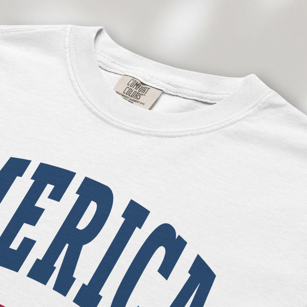 Closeup detail of white t-shirt with bold varsity text reading “America 250 — Est. 1776” in varsity style design.