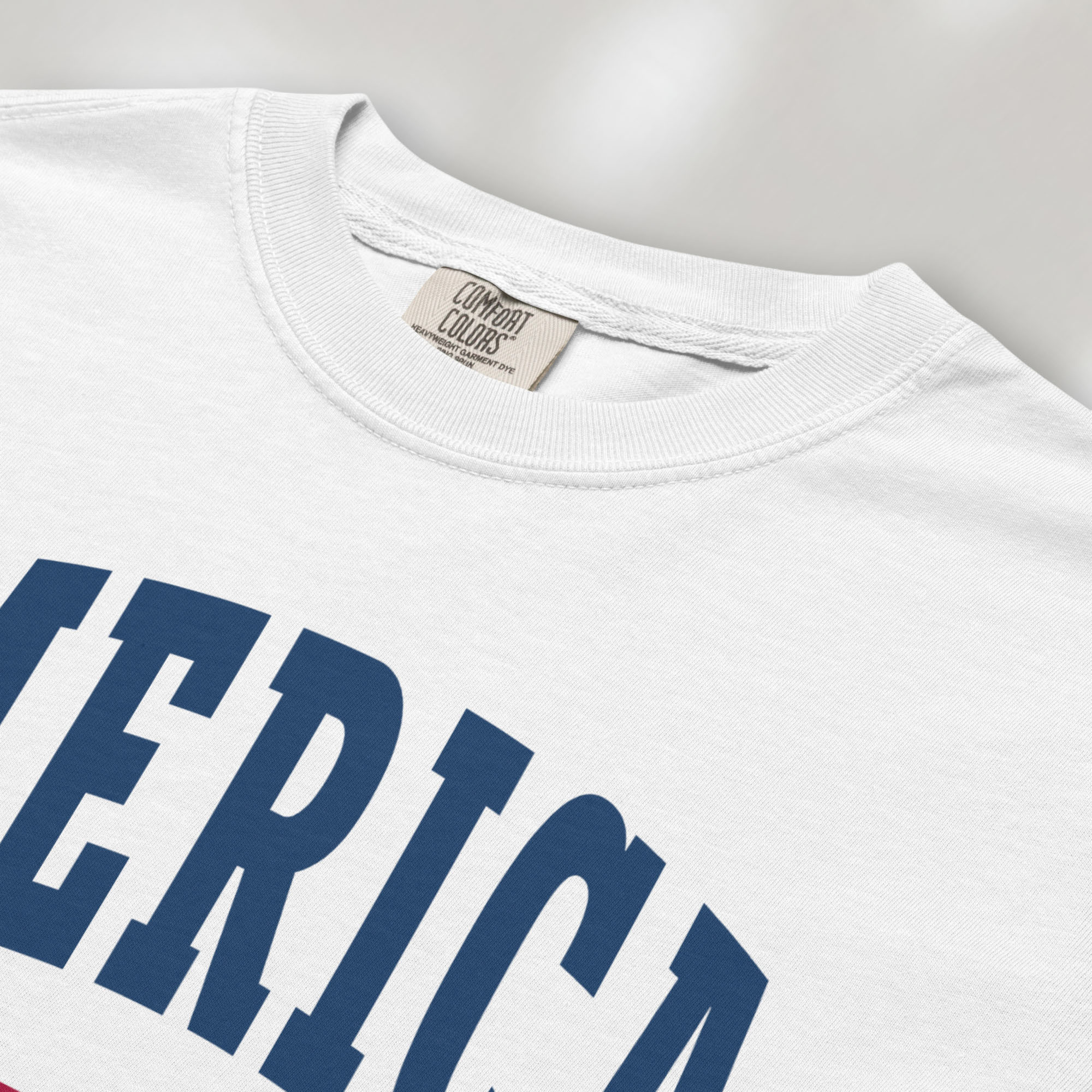 Closeup detail of white t-shirt with bold varsity text reading “America 250 — Est. 1776” in varsity style design.