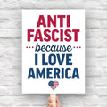 Downloadable, printable protest sign reading “Anti-Fascist Because I Love America” in red and blue lettering with patriotic heart design, anti-Trump rally poster.