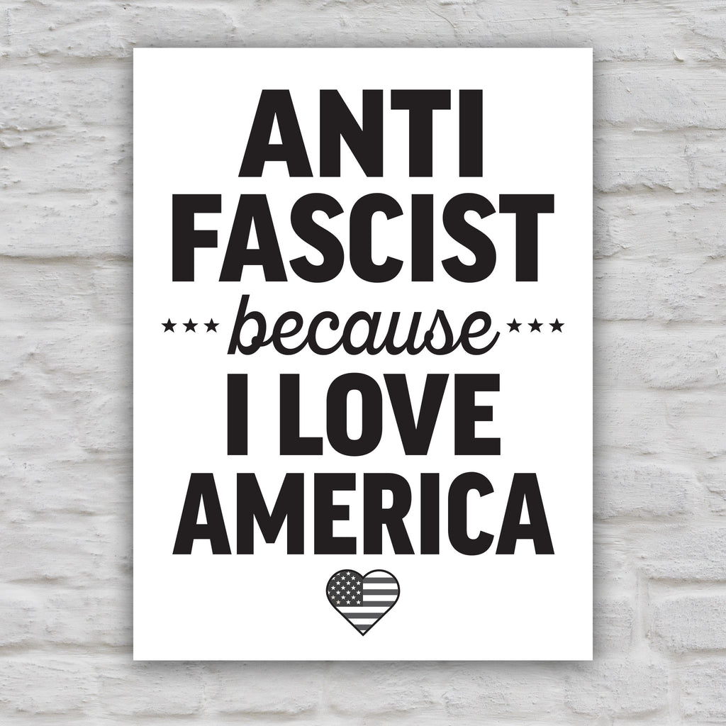 Black and white version of protest sign reading “Anti-Fascist Because I Love America” in bold lettering with patriotic heart design, anti-Trump rally poster.