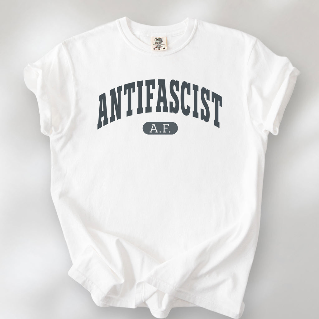 White Comfort Colors t-shirt with varsity collegiate style text across the front that reads "Antifascist AF."