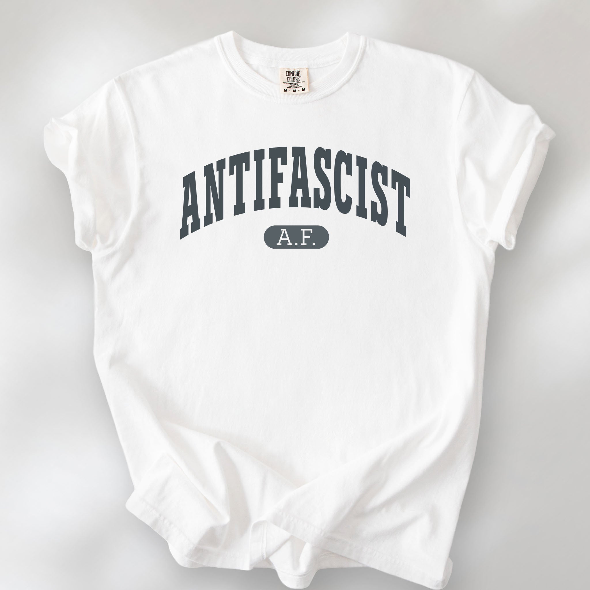 White Comfort Colors t-shirt with varsity collegiate style text across the front that reads "Antifascist AF."