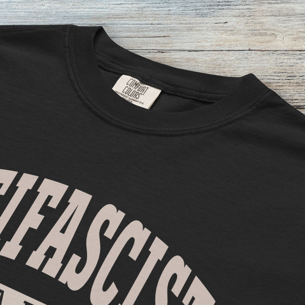 Closeup detail of back Comfort Colors t-shirt with varsity collegiate style text across the front that reads "Antifascist AF."