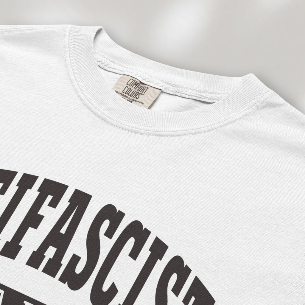 Closeup detail of white Comfort Colors t-shirt with varsity collegiate style text across the front that reads "Antifascist AF."