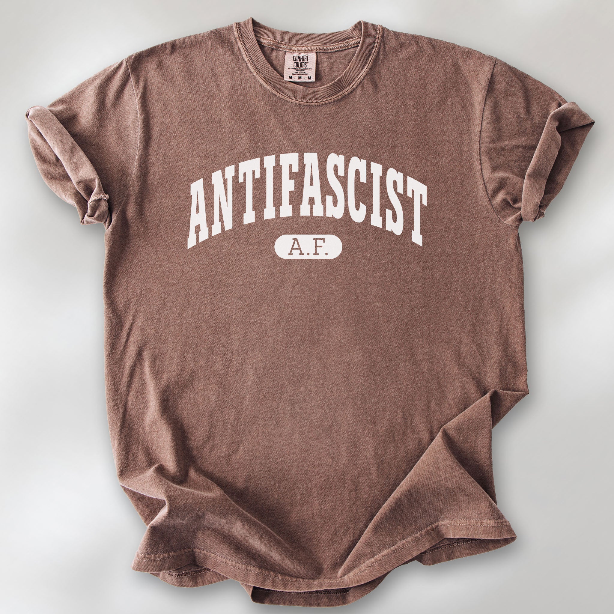Espresso Comfort Colors t-shirt with varsity collegiate style text across the front that reads "Antifascist AF."
