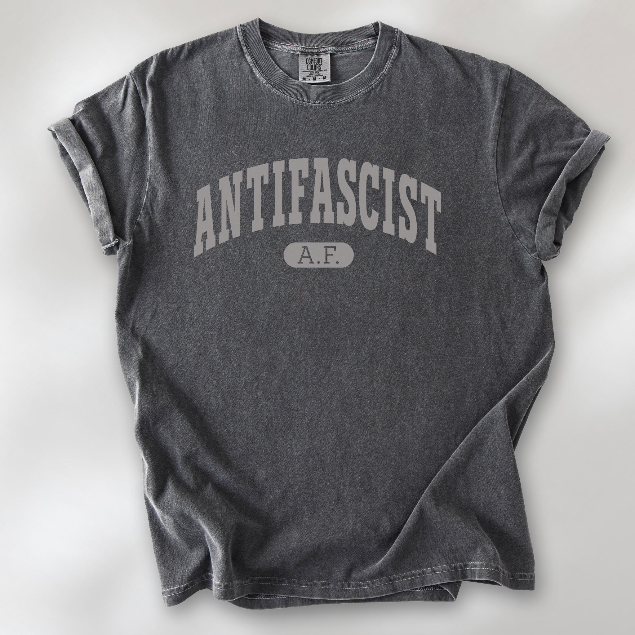 Pepper Comfort Colors t-shirt with varsity collegiate style text across the front that reads "Antifascist AF."