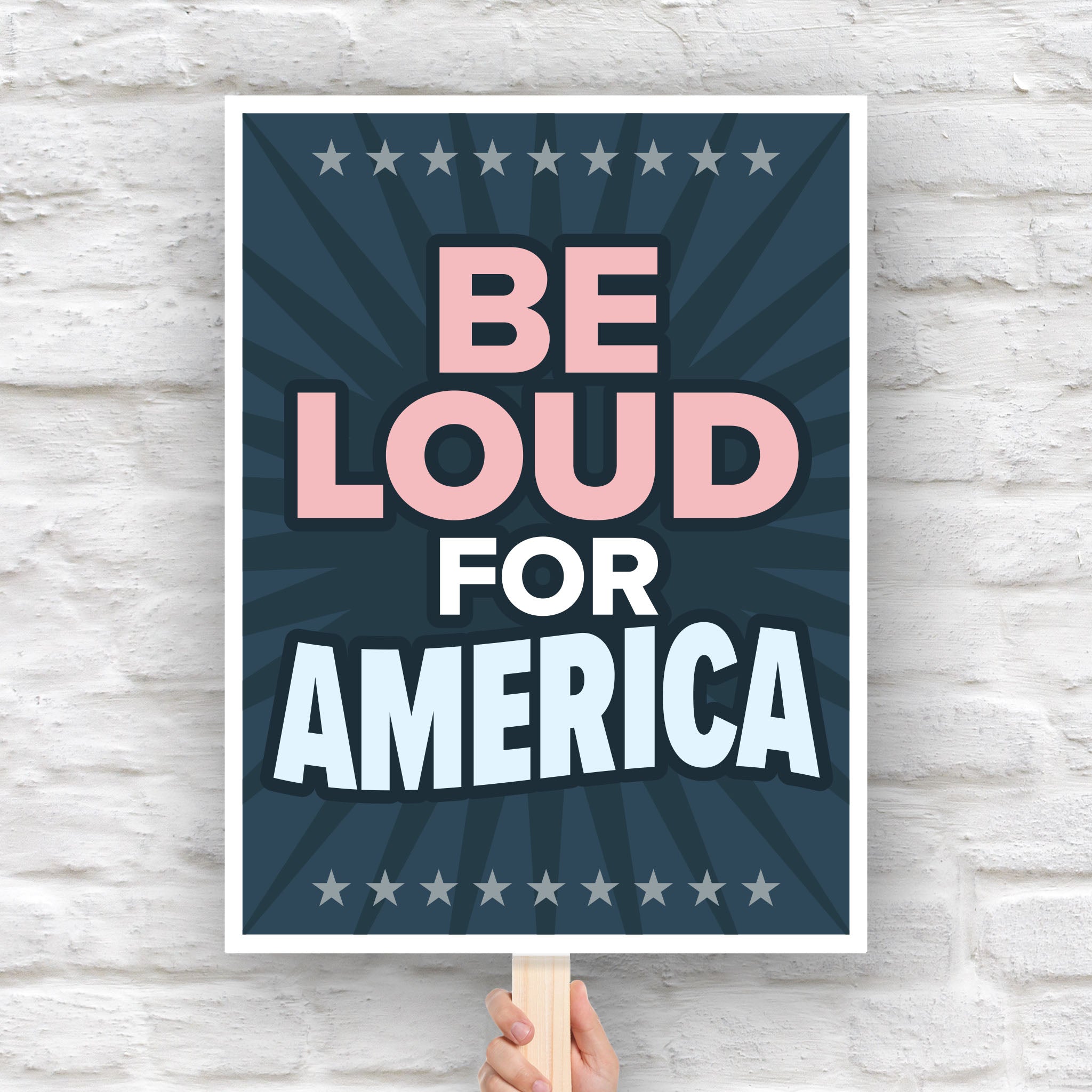 Bold protest sign with text “Be Loud for America” in patriotic colors, inspired by JB Pritzker urging people to speak up against Trump.
