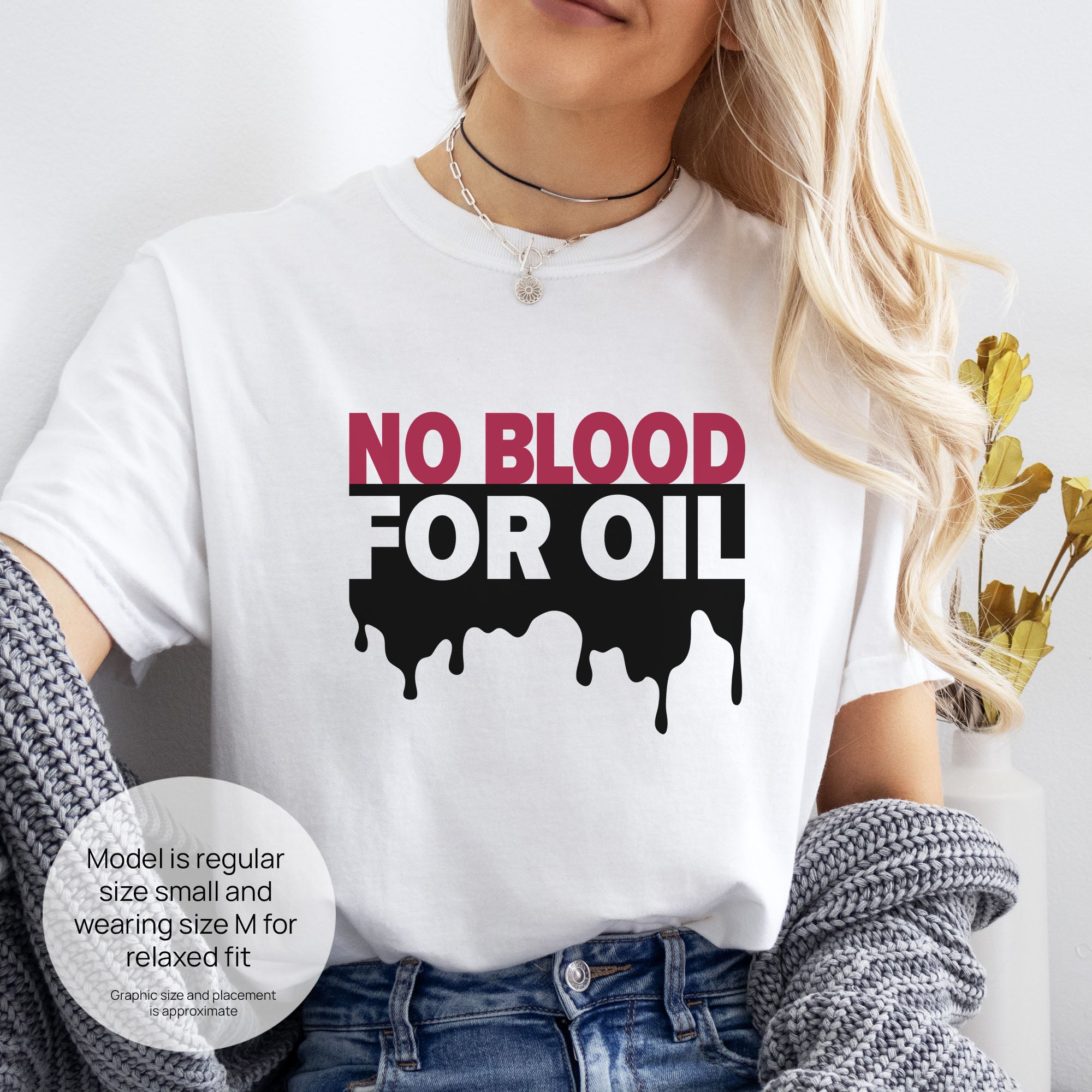 Female model wearing white protest t-shirt with bold text reading “No Blood for Oil” and dripping oil graphic, anti-war political shirt. Includes size and fit information for the model who is regular size small, and wearing a size M shirt for a relaxed fit.

