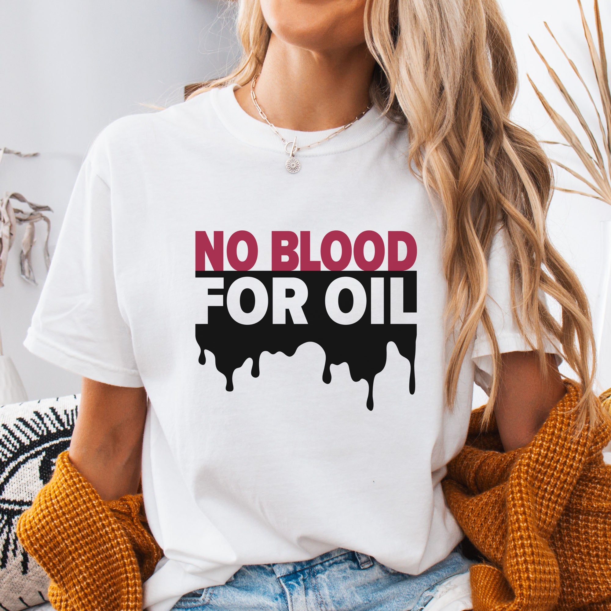 Female model wearing white protest t-shirt with bold text reading “No Blood for Oil” and dripping oil graphic, anti-war political shirt.