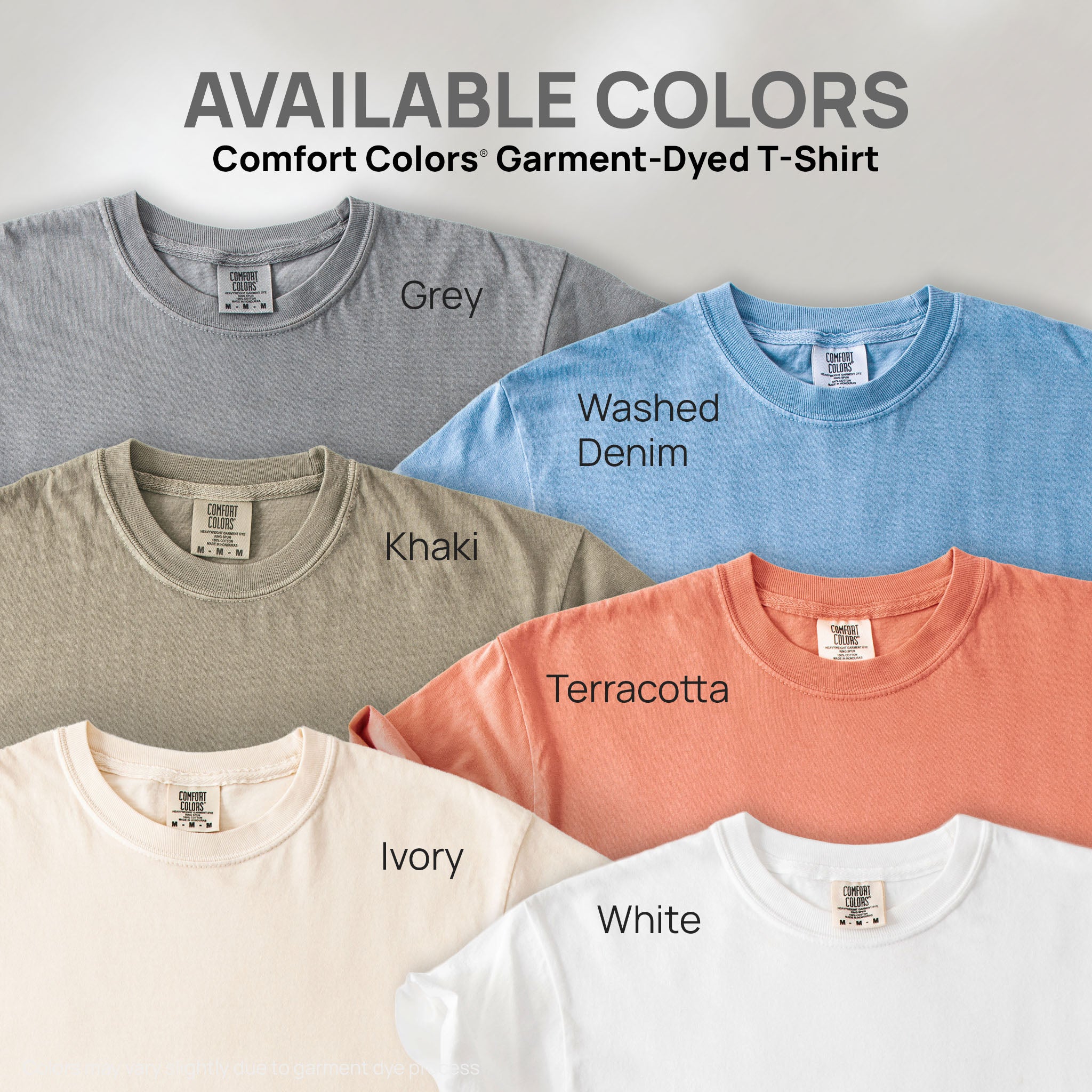 Six shirts showing the available colors for this Comfort Colors Garment-Dyed T-Shirt: grey, washed denim, khaki, terracotta, ivory, and white.
