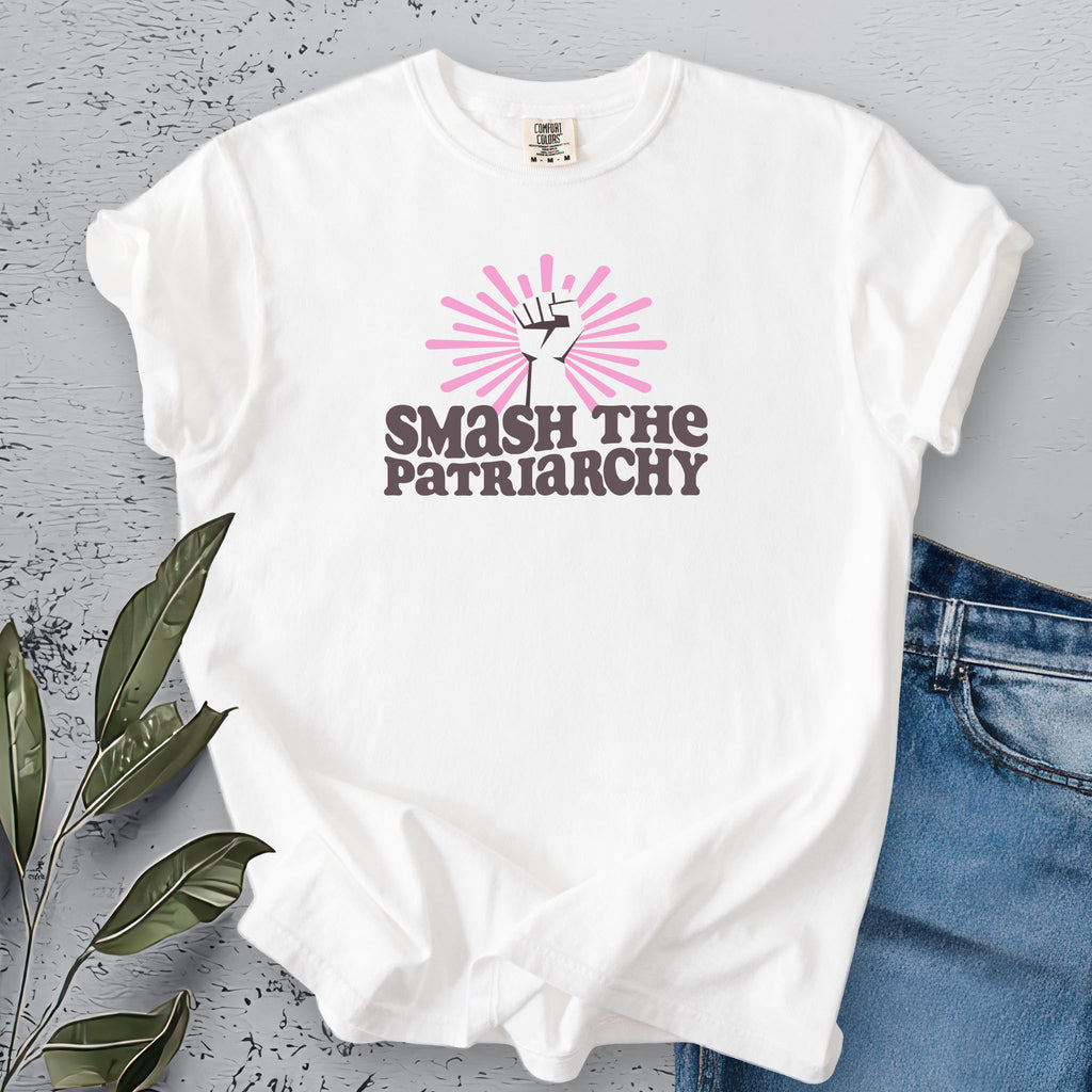White t-shirt with a raised fist graphic and pink rays behind it, featuring the text “Smash the Patriarchy.”