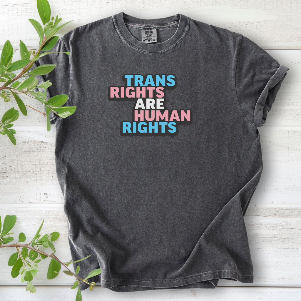 Pepper gray t-shirt with graphic that reads "trans rights are human rights" in the light blue, pink, and white colors of the trans flag, with a black shadow outlining the text.
