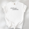 White t-shirt with minimalist serif text block reading “challenge authority."