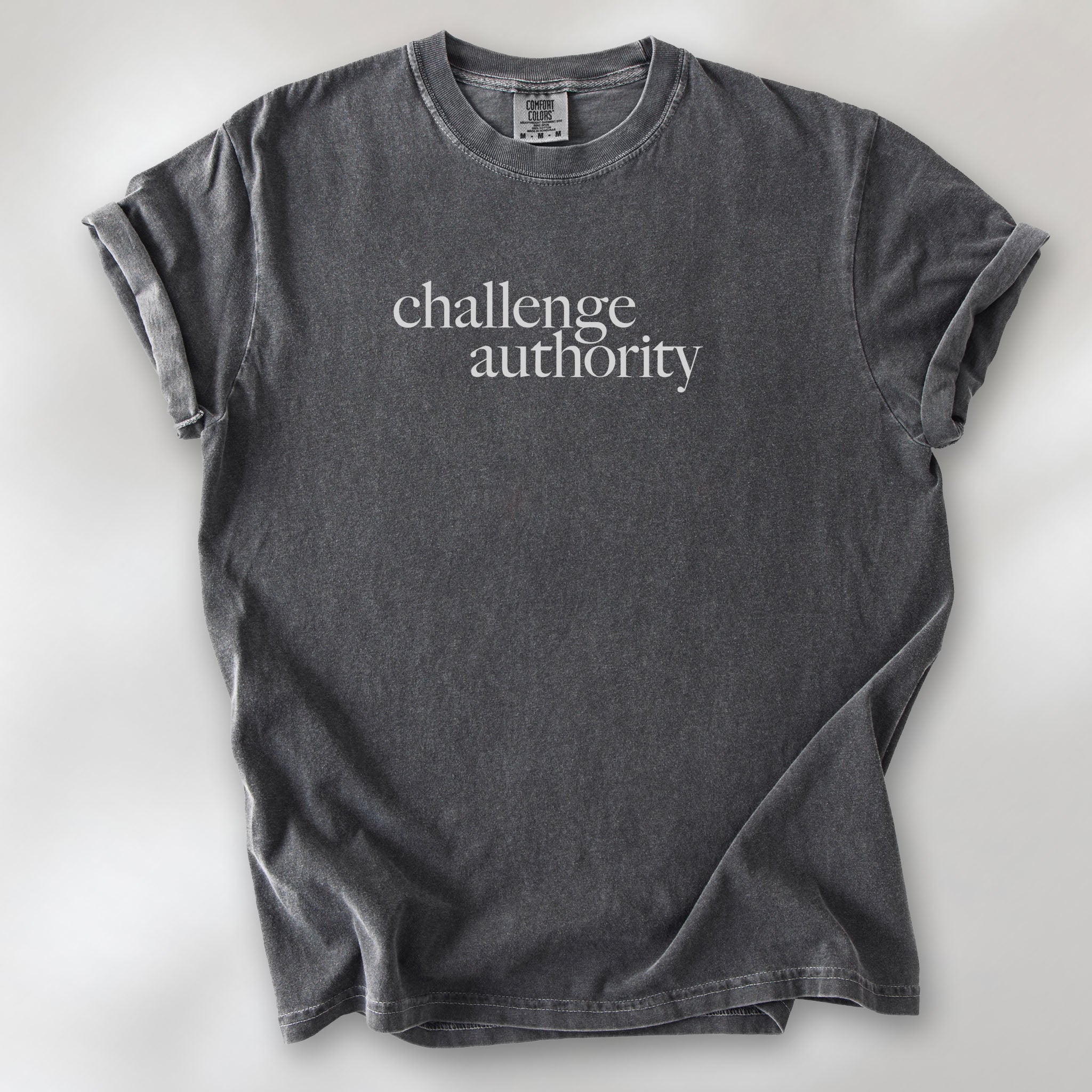 Pepper t-shirt with minimalist serif text block reading “challenge authority."