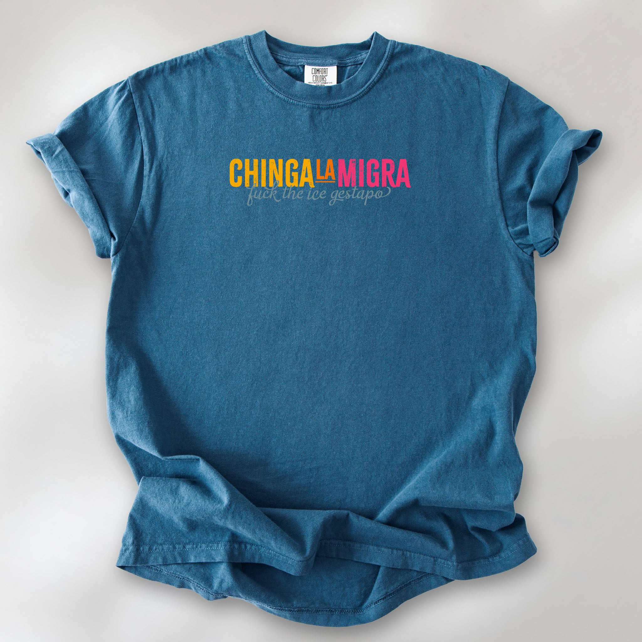 Midnight t-shirt with brightly colored text that reads "chinga la migra", with subtle script text below that says "fuck the ice gestapo."
