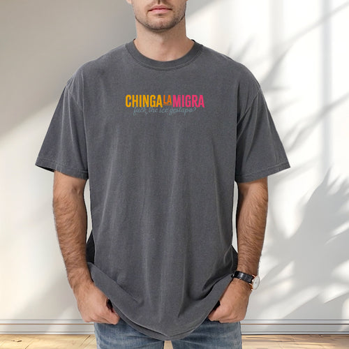 Male mode wearing grey t-shirt with brightly colored text that reads "chinga la migra", with subtle script text below that says "fuck the ice gestapo."