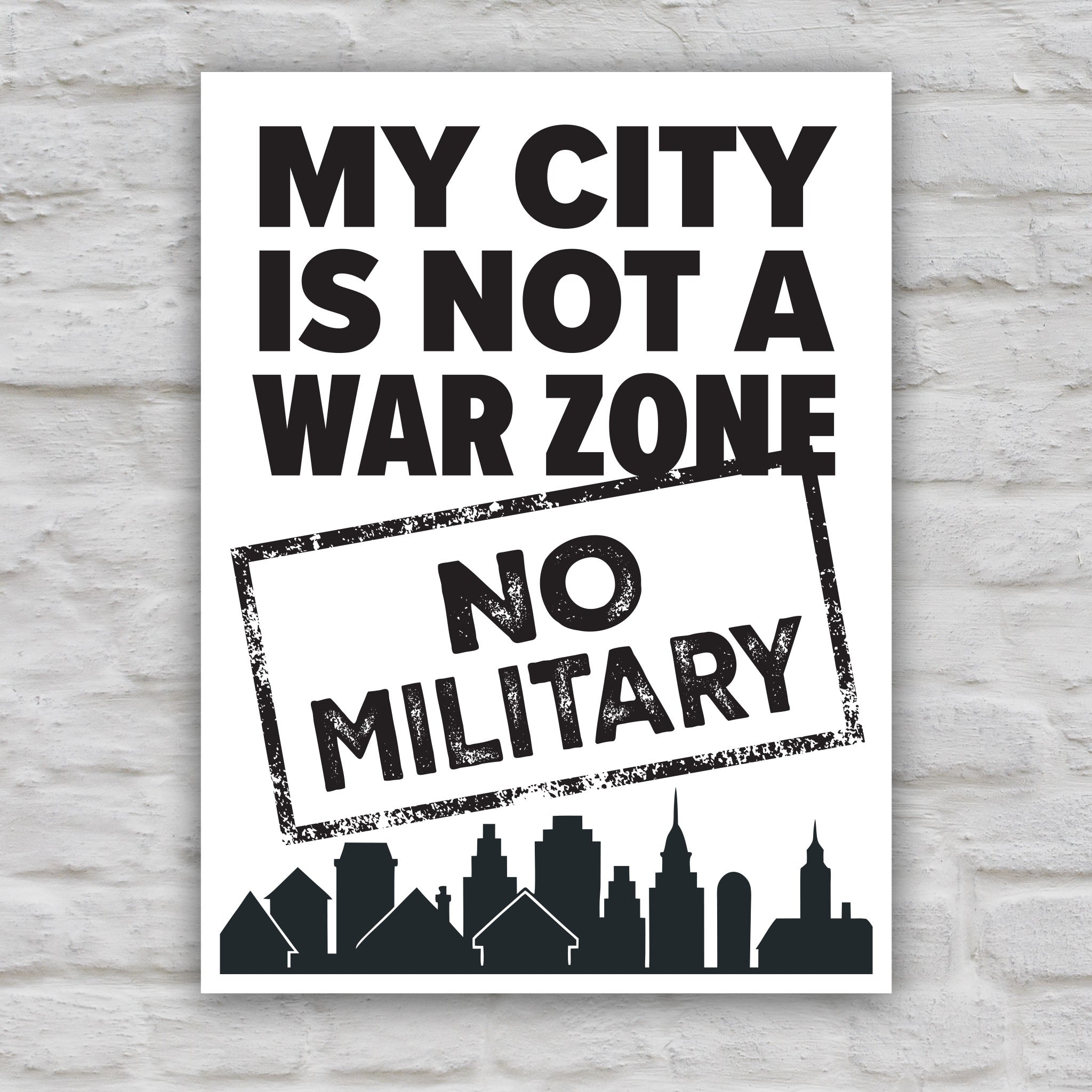 Black and white version of sign that reads "My City Is Not a War Zone – No Military" with bold lettering and a city skyline silhouette, anti-Trump political art.
