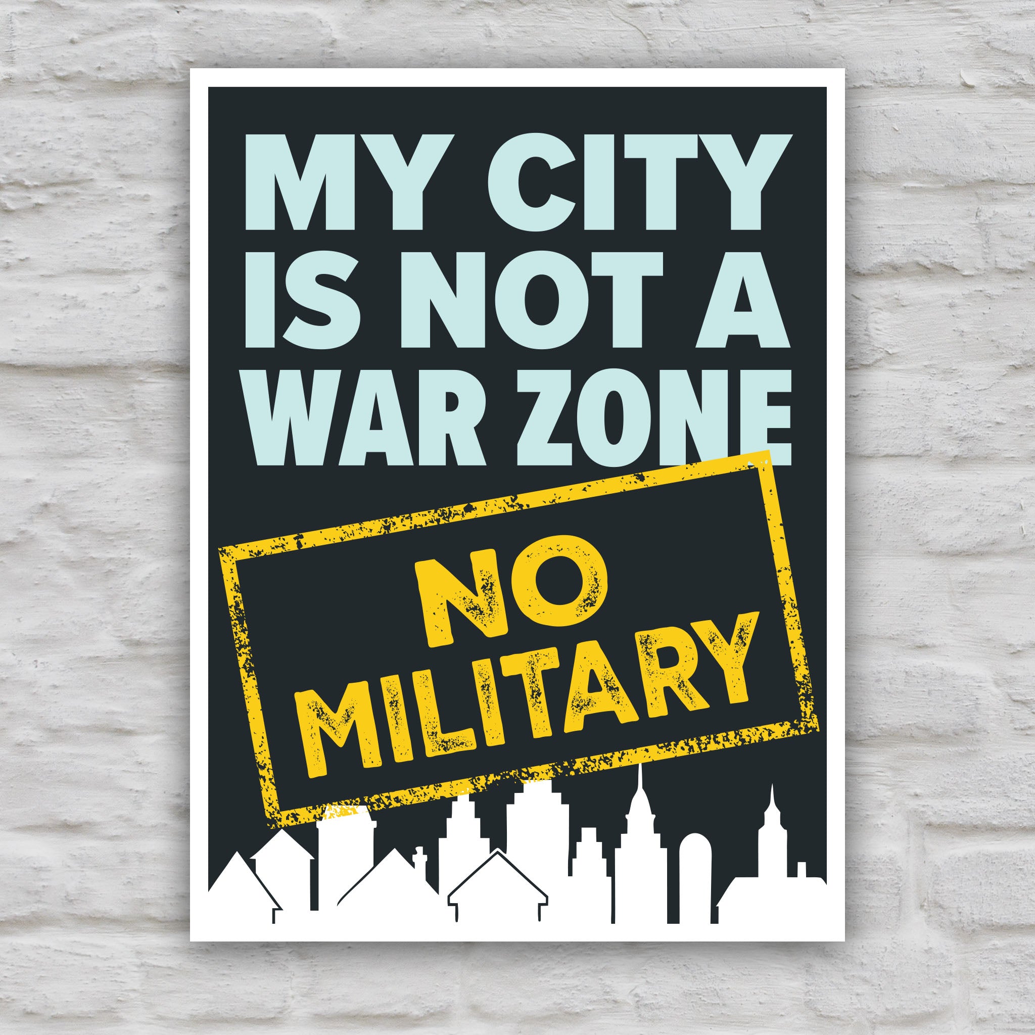 Color version of sign that reads "My City Is Not a War Zone – No Military" with bold lettering and a city skyline silhouette, anti-Trump political art.