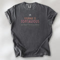 Pepper t-shirt with the words “Courage Is Contagious – Spread It Everywhere” printed in soft pink, coral, and gray.
