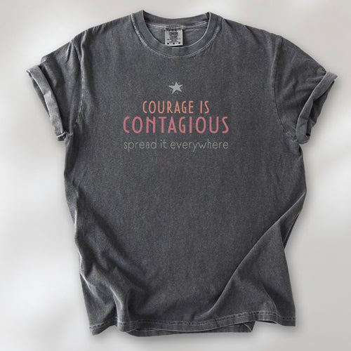 Pepper t-shirt with the words “Courage Is Contagious – Spread It Everywhere” printed in soft pink, coral, and gray.
