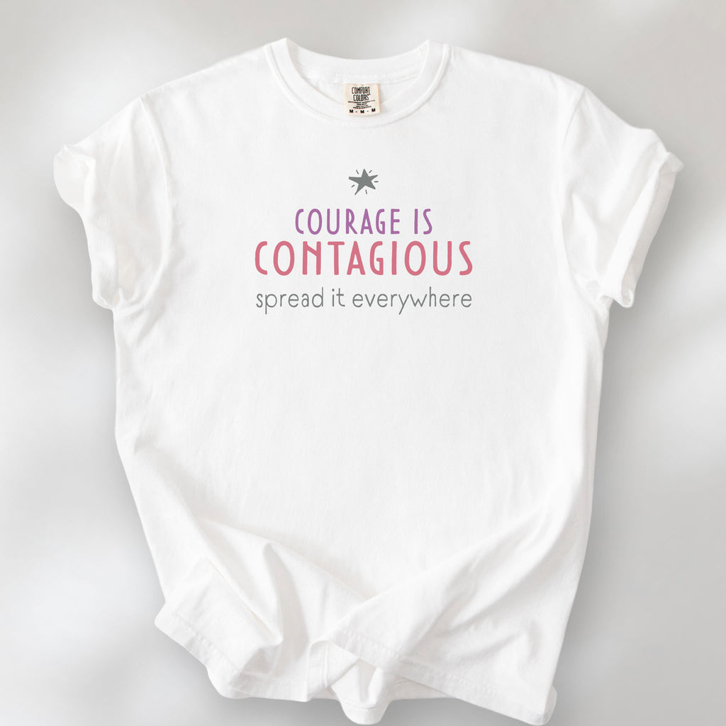 White t-shirt with the words “Courage Is Contagious – Spread It Everywhere” printed in soft purple, red, and gray.