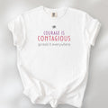 White t-shirt with the words “Courage Is Contagious – Spread It Everywhere” printed in soft purple, red, and gray.