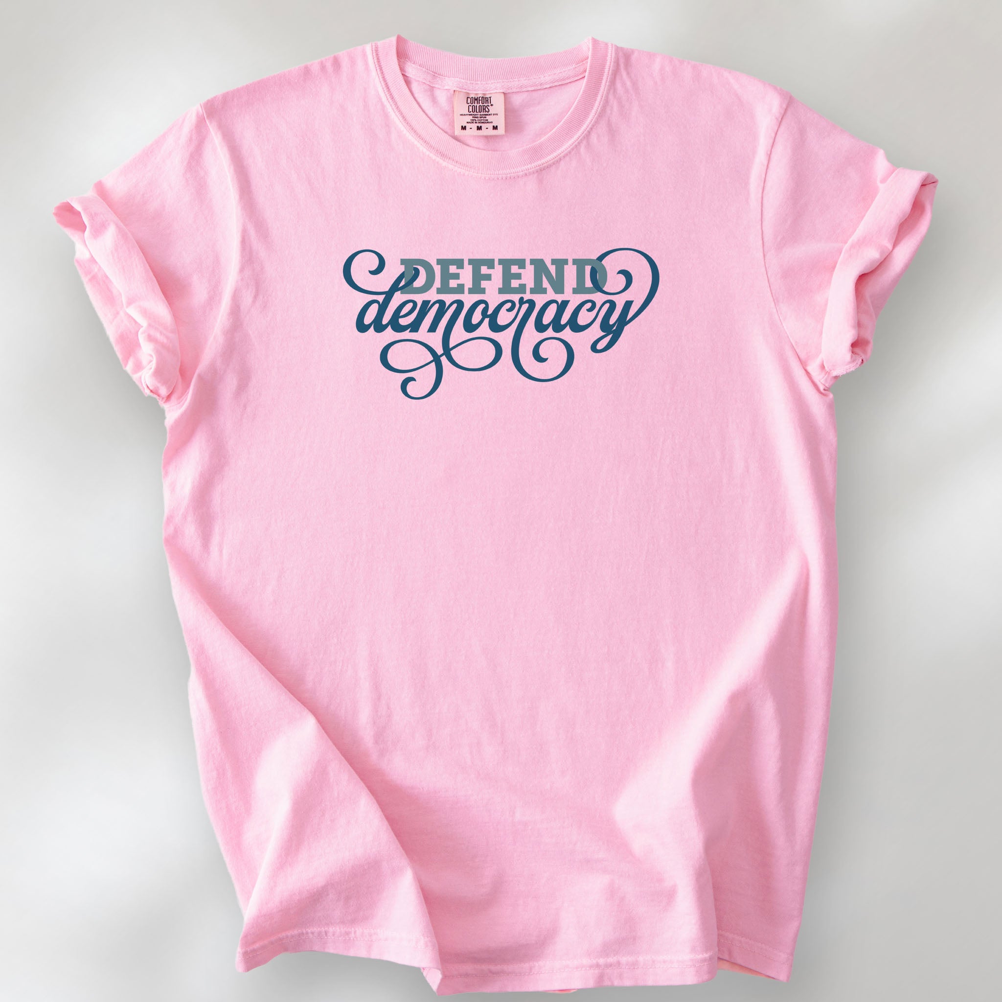 Blossom t-shirt with blue slab and script text reading “Defend Democracy.”